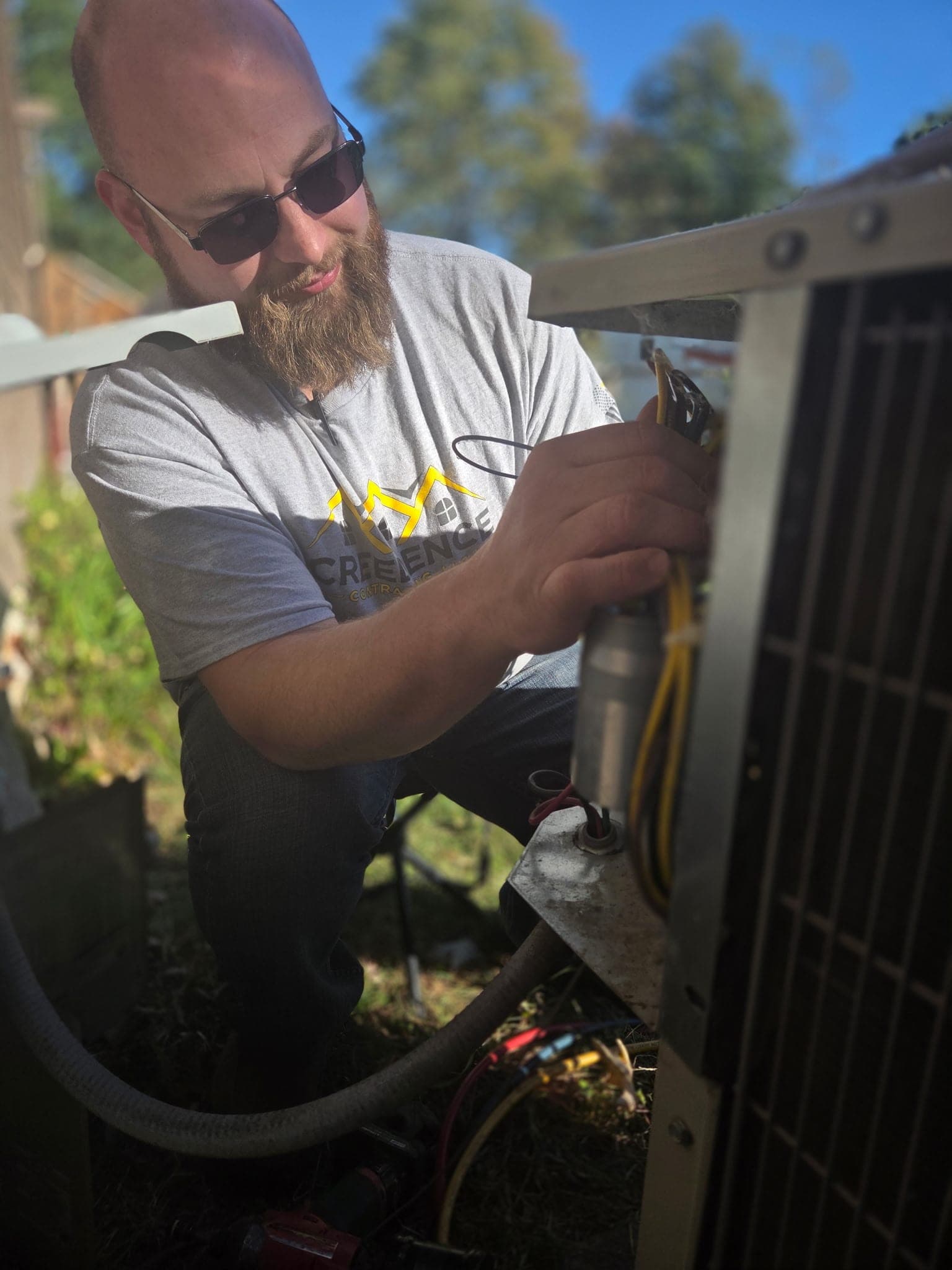 Creedence technician wiring an air conditioning condenser